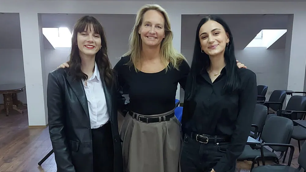 Three women facing the camera and smiling