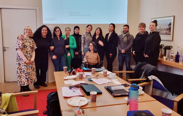A group picture of twelve people in a seminar room.