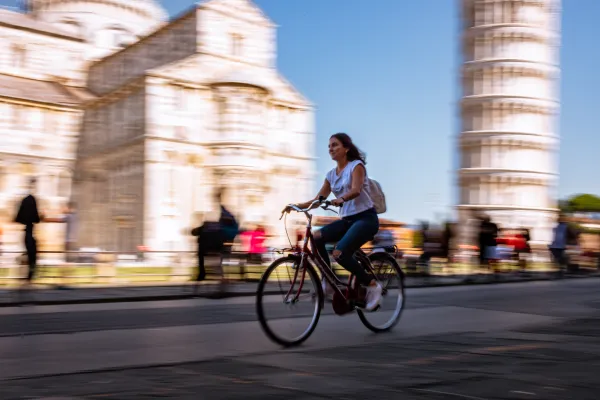 Student riding a bike under the leaning tower