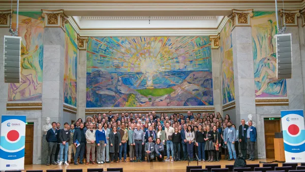 Group photo of Circle U. employees in front of the Edvard Munch painting "The Sun"