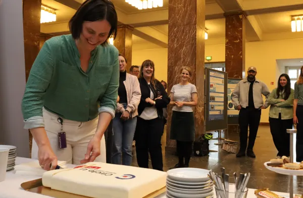 Cutting of the Circle U. birthday cake, guests standing in line for cake.